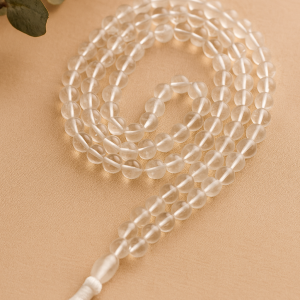 Clear quartz japa mala with 108+1 beads placed on beige background under natural light – handcrafted by Vedoorja Jaipur