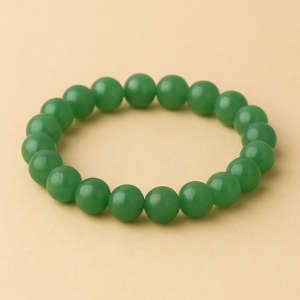 Simple green aventurine crystal bracelet on beige background – handcrafted by Vedoorja Jaipur