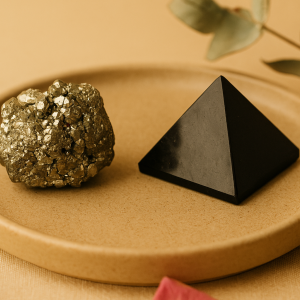 Raw pyrite crystal and black tourmaline pyramid on beige background with natural light – Vedoorja Jaipur